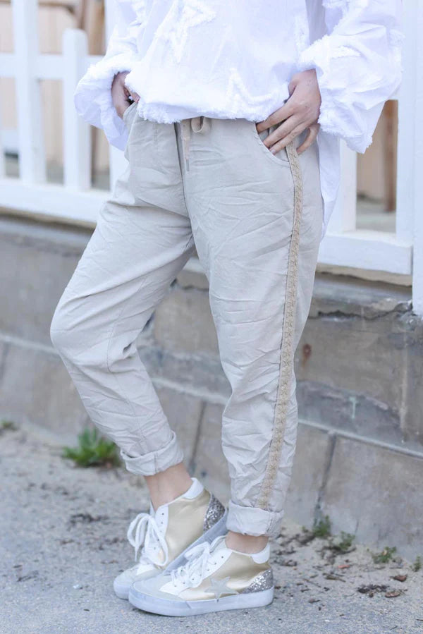 Beige stretch relaxed-fit trousers with embroidered star detail edging