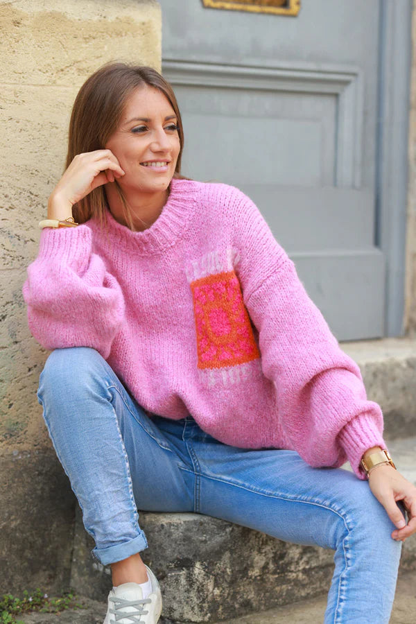 Pink chunky knit sweater with vibrant sun embroidery